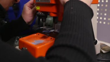 Anahtarları imalatı. Anahtarın bir kopyasını yapmak. Sihirbaz üstünde belgili tanımlık makine.