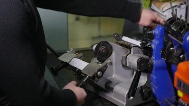 Anahtarları imalatı. Anahtarın bir kopyasını yapmak. Sihirbaz üstünde belgili tanımlık makine.