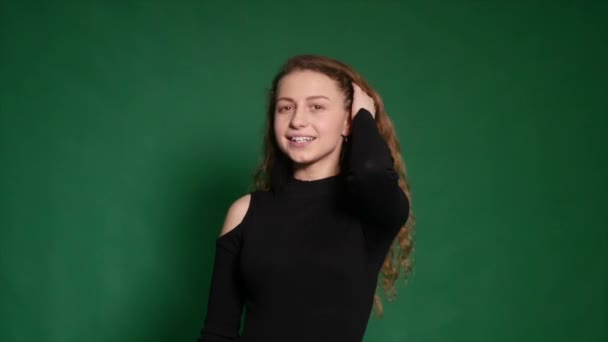 Красивая рыжая девушка показывает различные эмоции на зеленом фоне — стоковое видео