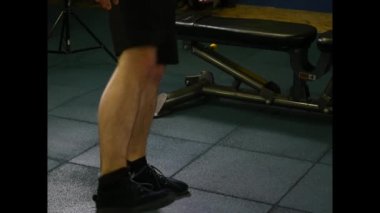 Genç adam spor salonunda egzersiz yapıyor.