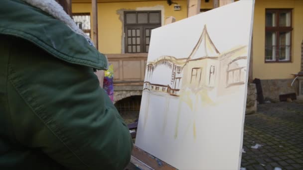 Meisje kunstenaar hand schilderij in oude straat — Stockvideo