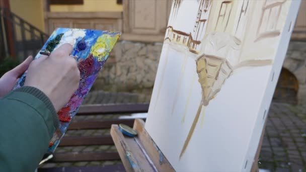 Flicka konstnären hand målning i gamla staden street — Stockvideo