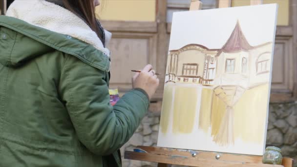 Junge Künstler ziehen in die Stadt. Künstler malen Bild auf der Straße. Studenten malen Gebäude der alten europäischen Stadt