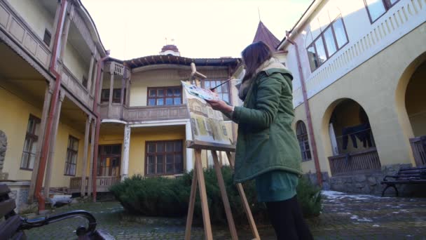 Jovens artistas atraem a cidade. Artistas a pintar quadros na rua. Estudantes pintam a construção da velha cidade europeia — Vídeo de Stock