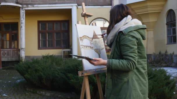 Giovani artisti disegnano in città. Artisti che dipingono quadri per strada. Gli studenti dipingono la costruzione della vecchia città europea — Video Stock