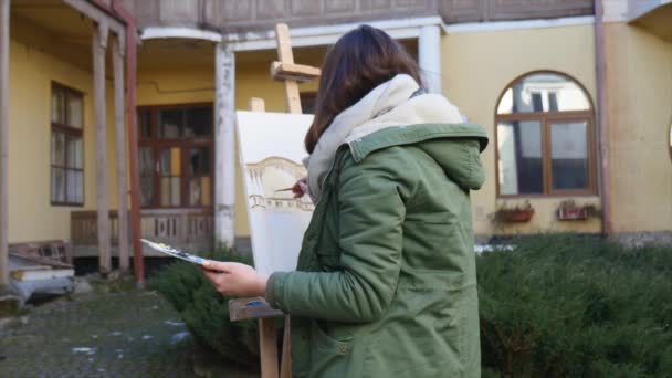 Jovens artistas atraem a cidade. Artistas a pintar quadros na rua. Estudantes pintam a construção da velha cidade europeia — Vídeo de Stock