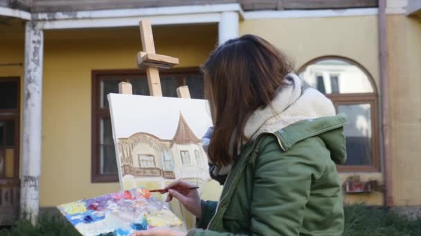 Jovens artistas atraem a cidade. Artistas a pintar quadros na rua. Estudantes pintam a construção da velha cidade europeia — Vídeo de Stock