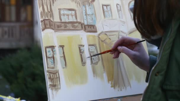 Dziewczyna ręką artysty malarstwo w starej ulicy miasta — Wideo stockowe