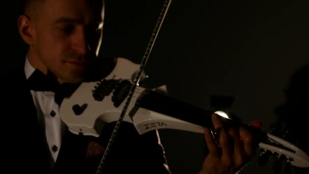 Violinist man playing the violin on a black background. Close up — Stock Video