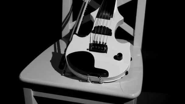 Violon blanc sur une chaise blanche sur fond noir — Video