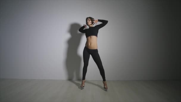 若いスリムなセクシーな金髪ポール ダンス女性がスタジオで運動。.灰色の背景に対して実行する魅力的な女性はセクシーなポール ダンサー — ストック動画