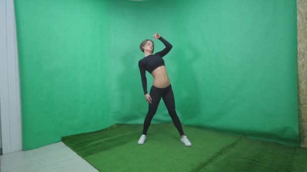 Sexy chica hace elemento en pole dance en verde fondo — Vídeos de Stock