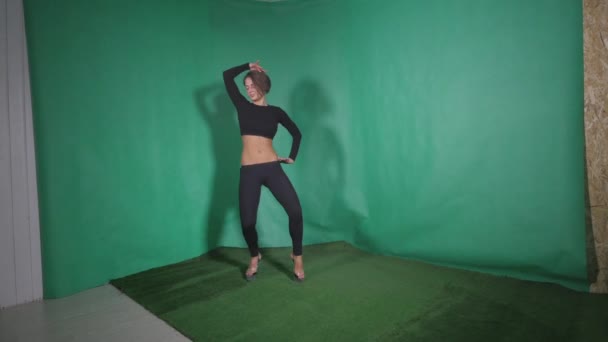 Σέξι κορίτσι κάνει στοιχείο στην πόλο χορού σε πράσινο φόντο — Αρχείο Βίντεο