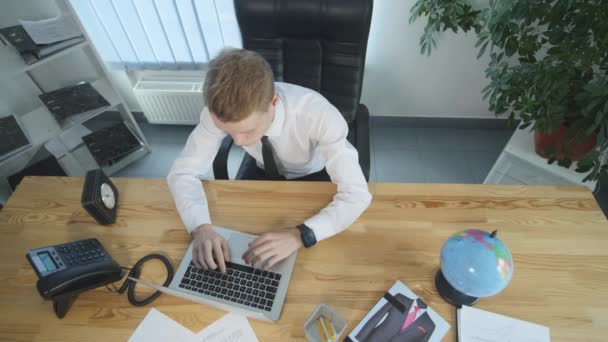 Cansado Jovem empresário trabalhando no computador portátil no escritório — Vídeo de Stock