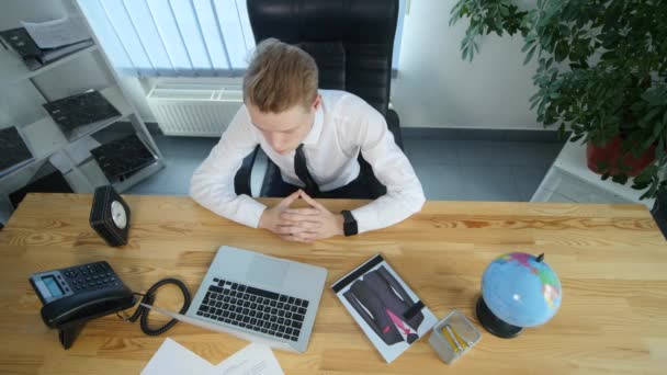 Affärsman som sitter i stol, vilar i office och vänder en tidskrift — Stockvideo