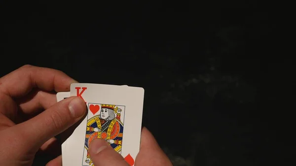 Hrací karty v ruce izolovaných na černém pozadí — Stock fotografie