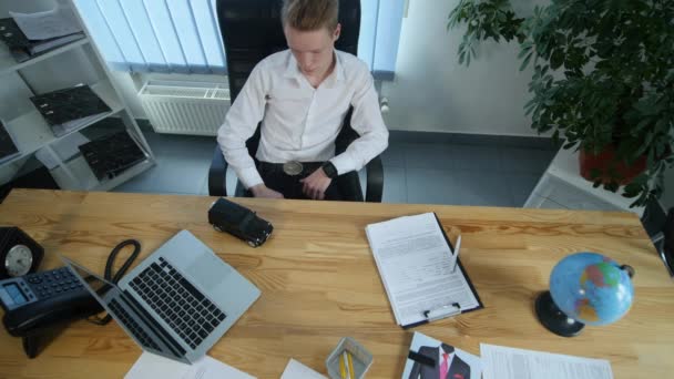 Fiatal üzletember játszik egy kis autó, az asztalon az irodájában — Stock videók