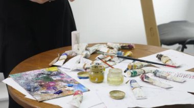 Çok renkli yağlı boya Resim Galerisi sanatçıları masasında. Boyalar ve sanatçılar gelen boş tüpler Tokmaklar masada mix