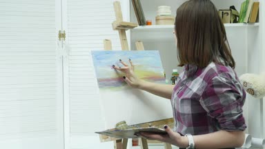 Genç bir kadın bir resim arkasında, atmosferik bir atölye bir şövale bir tuval üzerine boya