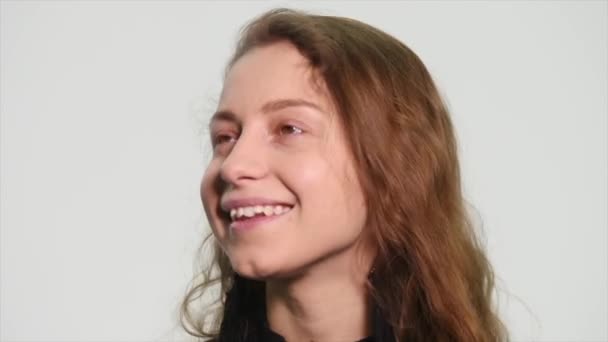 Портрет красивой женщины, улыбающейся на белом фоне — стоковое видео