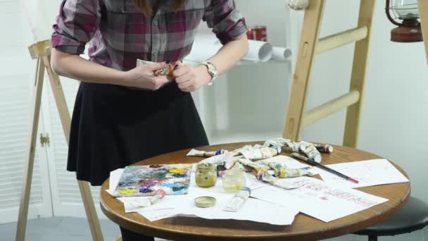 パレットに絵の具のチューブを女性の手のクローズ アップ ショット — ストック動画