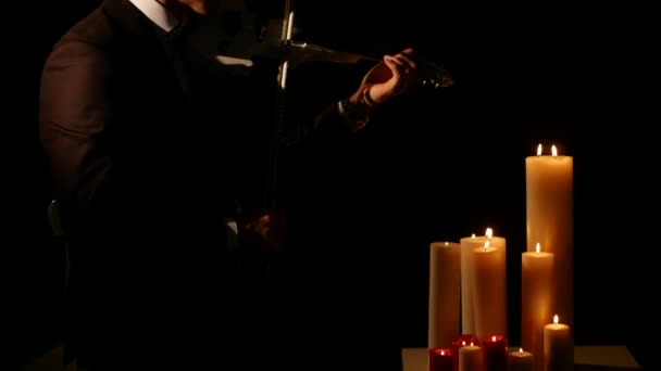 Close up Violin player playing the intstrument on black background with candles — Stock Video