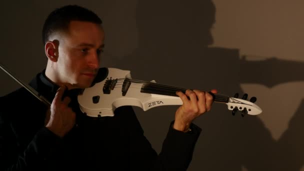 Скрипач играет на скрипке на черном фоне. Закрыть — стоковое видео