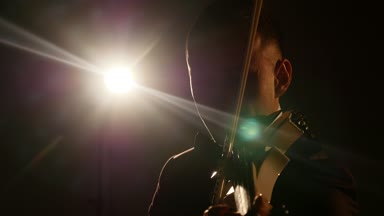Müzisyen şarkı kemancı keman enstrümanı senfonik konser solist oynuyor. dedolight arka plan