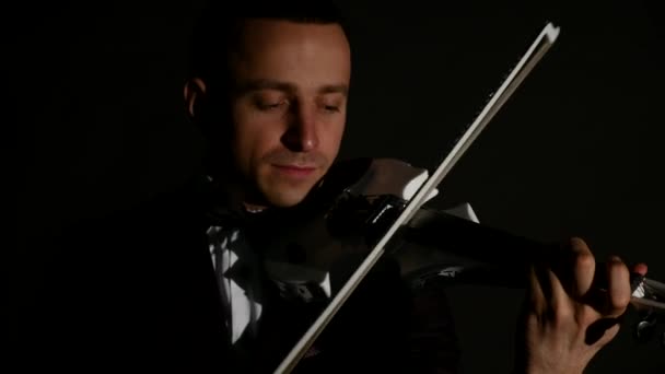Скрипаль грає на скрипці на чорному тлі. крупним планом — стокове відео