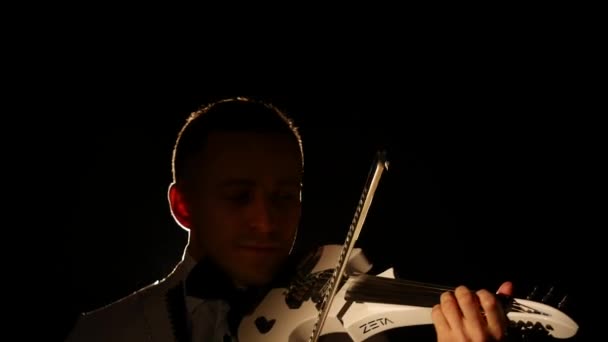Homem violinista a tocar violino num fundo negro. Fechar — Vídeo de Stock