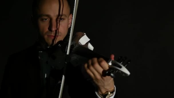 Homem violinista a tocar violino num fundo negro. Fechar — Vídeo de Stock
