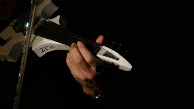 Kemancı adam siyah bir arka planda keman çalıyor. Yakın çekim