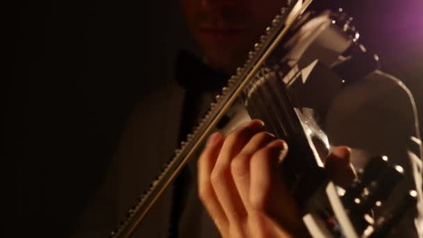 Młody człowiek gra na skrzypcach w ciemnym pokoju — Wideo stockowe