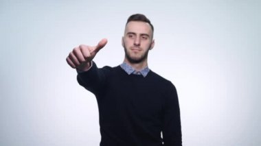 Başparmak aşağı gösterilen genç adam. Stüdyo vurdu. Beyaz arka plan