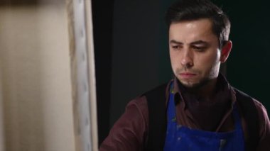 Sanatçı-ressam boyalar stüdyoda bir resmi. O genç ve çekici.