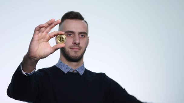 Un joven con un bitcoin moneda — Vídeos de Stock