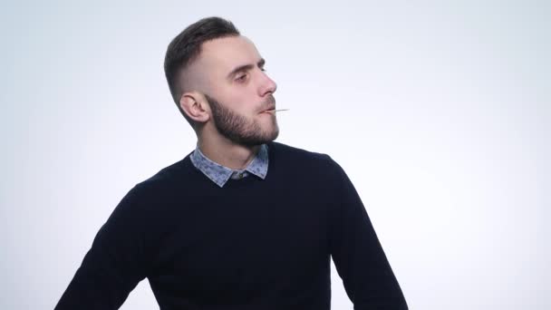 Creatief leuk jong guy kijken naar camera met tandenstoker in zijn mond closeup concept van emoties — Stockvideo