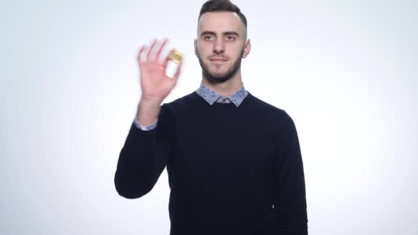 Un joven con un bitcoin moneda — Vídeo de stock