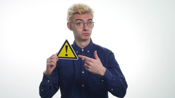 Mladý muž, který držel znamení nebezpečí na bílém pozadí — Stock video