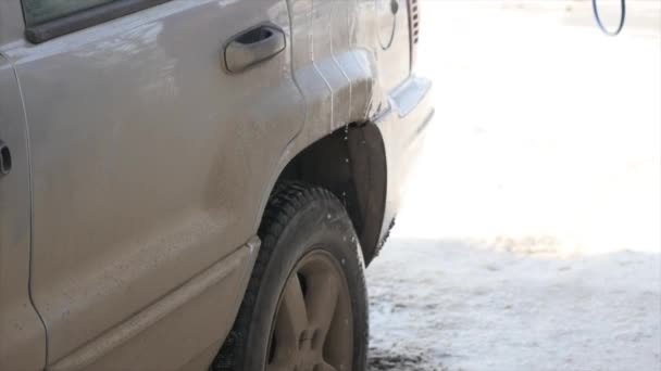 Werknemer wassen auto sterke stromen van water winter — Stockvideo