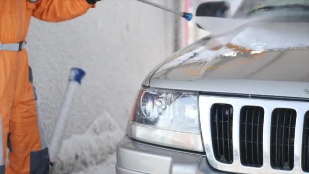 Werknemer wassen auto sterke stromen van water winter — Stockvideo