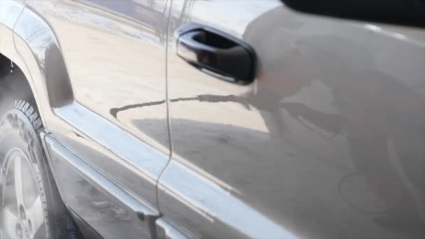 Munkavállaló mosás autó erős patakok a víz télen — Stock videók