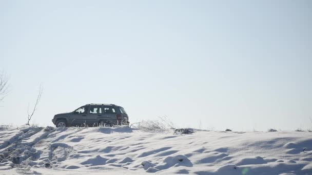 DRIVING IN THE SNOW. Winter car tracks on snowy beach. Driving a race car on a snowy road. Track Winter car racing with sun reflection. Race on the track in the winter — Stock Video