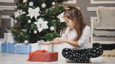 Beklenmedik bir hediye güzel bir kıza gelir, şaşırır, kutuyu alır ve göğsüne yakın tutar..