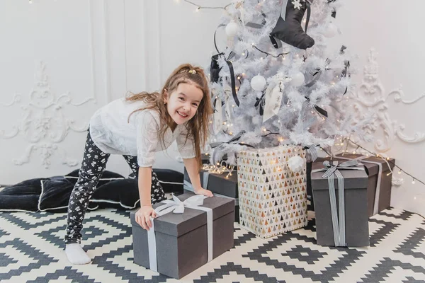 Carino super eccitato giovane ragazza è pronta ad aprire un grande regalo di Natale . — Foto Stock