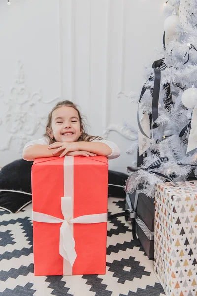 Descuidado, sorrindo pequena fêmea desfrutando de tempo de Natal e presentes . — Fotografia de Stock