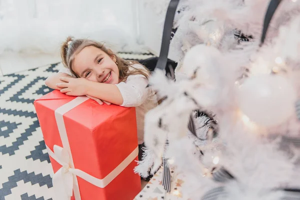 Descuidado, sorrindo pequena fêmea desfrutando de tempo de Natal e presentes . — Fotografia de Stock