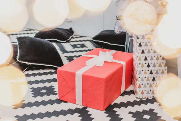 Delikat xmas bakgrund med röd jul låda bunden med vitt band och bokeh lampor på framsidan. — Stockfoto