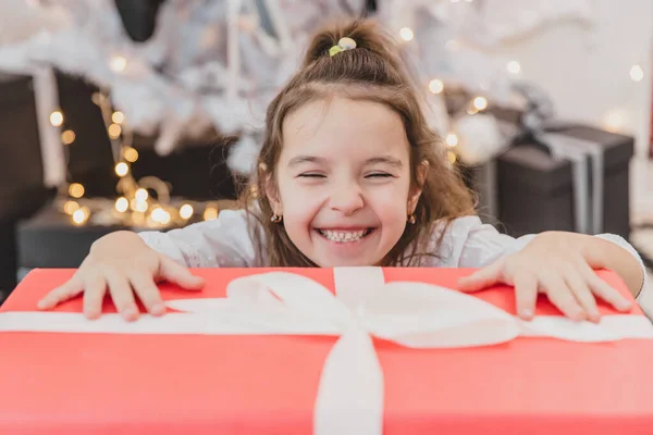 Nahaufnahme Foto von super aufgeregt junges Mädchen öffnet großes Weihnachtsgeschenk, während es auf dem Wohnzimmerboden sitzt. — Stockfoto