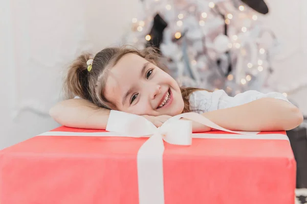 Gros plan photo de fille douce avec queue de cheval dort sur un grand cadeau de Noël, à la recherche incroyable . — Photo